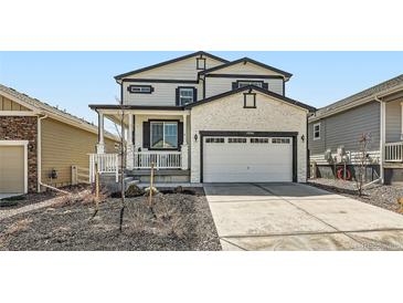 Charming two-story home featuring a two-car garage and a welcoming front porch with white trim at 1994 Spencer Ave, Castle Rock, CO 80104