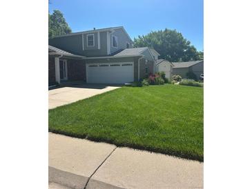 Well maintained two story home, with a beautiful lawn, driveway, and attached two car garage at 5612 S Lansing Ct, Englewood, CO 80111