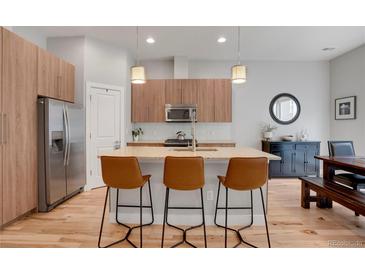 Stylish kitchen with wood cabinets, granite countertops, stainless steel appliances, and a breakfast bar with seating at 1921 Hooker St, Denver, CO 80204