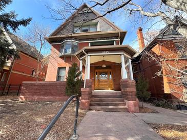 Charming two-story brick home featuring a welcoming front porch and classic architectural details at 1625 N Downing St, Denver, CO 80218