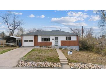 Charming ranch-style home with a brick facade, attached garage, and mature trees under a bright blue sky at 12023 W Virginia Ave, Lakewood, CO 80228