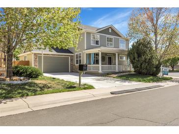 Charming two-story home with a stone-accented garage, inviting front porch, and a well-manicured lawn at 3406 Purcell St, Brighton, CO 80601
