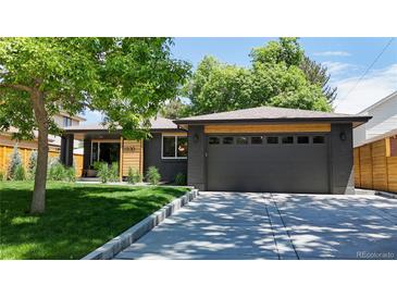 Charming single-story home featuring a sleek dark gray exterior, lush green lawn, and a modern garage door at 1830 S Fillmore St, Denver, CO 80210