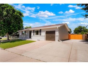 Charming single-story home with a well-manicured lawn, a driveway, and an attached single car garage at 5554 Crystal Way, Denver, CO 80239