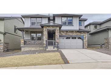 Charming two-story home featuring stone accents, a covered porch, and an attached two-car garage at 15153 W Dequesne Ave, Morrison, CO 80465