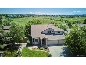 Charming two-story home with well-manicured lawn, mature trees, and three car garage at 984 Shadow Mountain Dr, Highlands Ranch, CO 80126