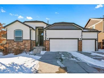 Two-story house with a three-car garage and stone accents at 6829 Juniper Ct, Frederick, CO 80530