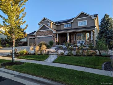 Beautiful two-story home with manicured front yard, stone accents, and a welcoming front porch at 7765 Yankee Ct, Arvada, CO 80007