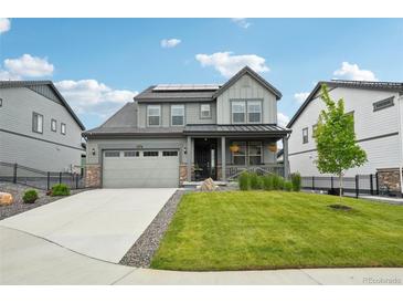 Charming two-story home with a well-manicured lawn and solar panels on the roof at 3365 S Poppy St, Morrison, CO 80465