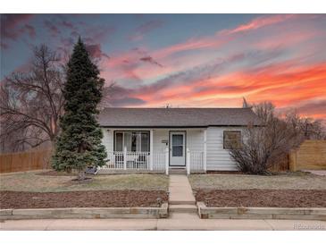 Charming home featuring a cozy front porch and beautiful landscaping under a vibrant sunset sky at 5191 S Logan St, Littleton, CO 80121