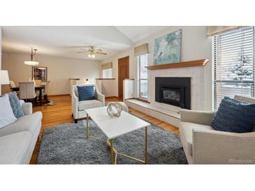 Bright living room with a fireplace and ample natural light provides a cozy atmosphere at 3079 E Long S Cir, Centennial, CO 80122