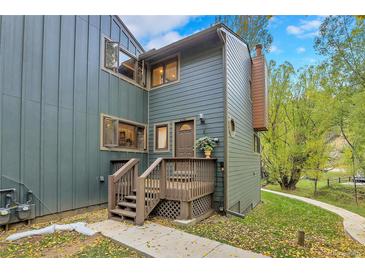 Charming multi-level home featuring a welcoming porch, with green siding, and well-maintained landscaping at 4863 Silver Spruce Ln, Evergreen, CO 80439