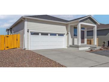 Charming home featuring a two car garage, concrete driveway, and well-maintained landscaping at 18338 E 93Rd Pl, Commerce City, CO 80022