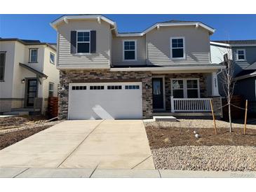 Charming two-story home featuring a spacious garage, stone accents, and a welcoming front porch at 3373 N Catawba Way, Aurora, CO 80019