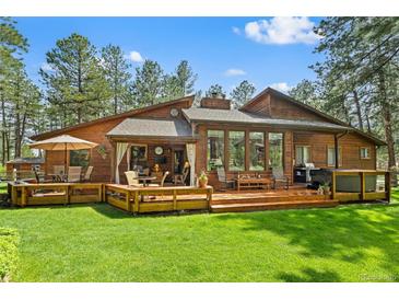Stunning wood home featuring an expansive deck perfect for entertaining and relaxing outdoors at 4407 Delaware Dr, Larkspur, CO 80118