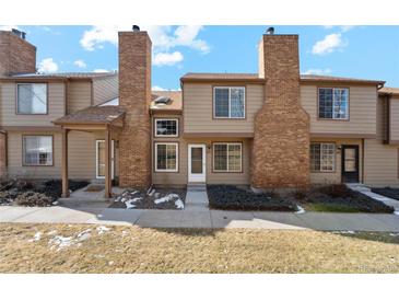 Charming townhome featuring a private entry, brick chimney, and well-kept front yard at 892 Summer Dr # 15B, Highlands Ranch, CO 80126