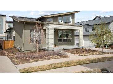 Modern home exterior with a covered porch and well-maintained yard, showcasing its contemporary design at 5050 Akron St, Denver, CO 80238