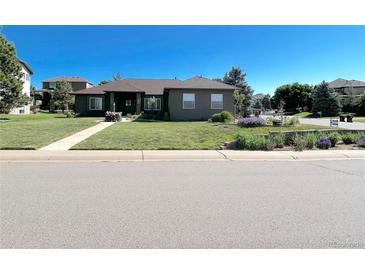 Charming single-story home with a well-manicured lawn, mature trees, and inviting curb appeal at 7170 Windwood Way, Parker, CO 80134