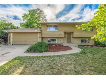 Charming home featuring a two-car garage, well-maintained lawn, and an inviting entrance at 12883 E Nevada Cir, Aurora, CO 80012