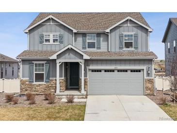 Charming two-story home features a two-car garage, gray siding, stone accents, and matching gray shutters at 6243 Saddle Bow Ave, Parker, CO 80134