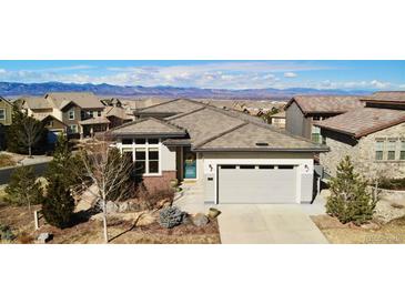 Stunning exterior elevation showcasing the beautifully landscaped yard and mountain views at 775 Woodgate Dr, Littleton, CO 80126