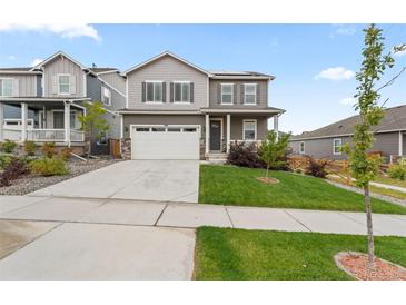 Charming two-story home with a well-manicured lawn, two-car garage, and inviting front porch at 14075 Scarlet Sage St, Parker, CO 80134