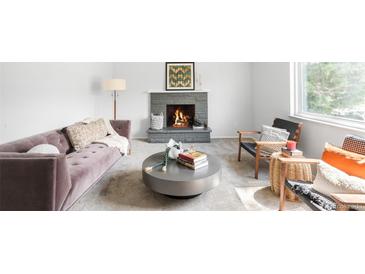 Bright living room with a stone fireplace, plush mauve couch, and modern decor at 3322 Simms St, Wheat Ridge, CO 80033