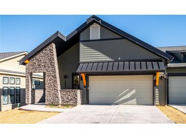 Striking home exterior featuring stone accents, a dark roof, and a two-car garage at 3909 Piney Grove St, Evergreen, CO 80439
