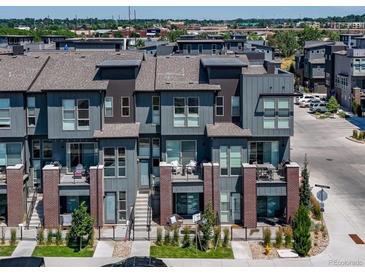 Modern townhome with gray exterior, brick accents, and private balconies in a contemporary community setting at 5021 S Prince Pl, Littleton, CO 80123