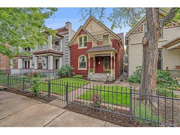 Charming two-story home boasts a well-manicured front yard and inviting curb appeal with black iron fence at 1356 N Marion St, Denver, CO 80218