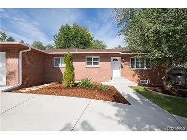 Charming brick home with a well-manicured front yard and a concrete driveway under a sunny sky at 6769 S Foresthill St, Littleton, CO 80120