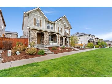 Charming two-story home with stone accents, manicured lawn, and inviting curb appeal at 7602 S Yakima Ct, Aurora, CO 80016
