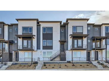 Modern townhome showcasing a sleek exterior with private balconies and contemporary design at 664 Saddle Dr, Erie, CO 80516