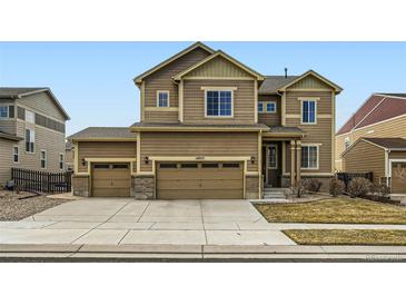 Inviting two-story home featuring a three car garage and a meticulously maintained lawn at 10057 Granby St, Commerce City, CO 80022