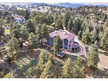 Stunning aerial view of a home with lush greenery and a circular driveway at 24140 Us Highway 40, Golden, CO 80401