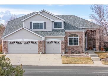 Two-story house with brick and siding, three-car garage, and landscaped yard at 18981 E Belleview Pl, Centennial, CO 80015