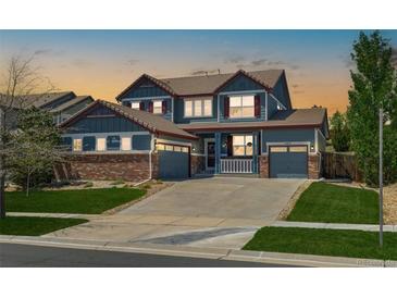 Charming two-story home boasting a well-manicured lawn and a welcoming front porch at 11957 S Swift Fox Way, Parker, CO 80134
