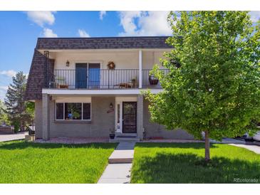 Two-story home featuring two balconies, a manicured lawn, and traditional design at 11402 W 17Th Pl, Lakewood, CO 80215