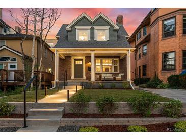 Charming brick home with a covered front porch, columns, and landscaped front yard at 1730 N Gaylord St, Denver, CO 80206