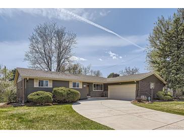 Charming single-story home features a well-manicured lawn, a circular driveway, and a two-car garage at 5876 W Canyon Ave, Littleton, CO 80128