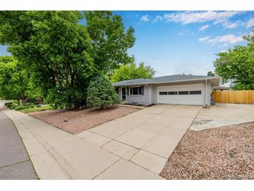 Charming single-story home with a two-car garage and mature trees in a well-maintained front yard at 8231 E Lehigh Dr, Denver, CO 80237