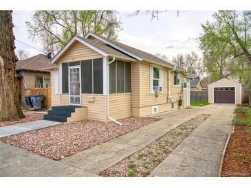 Charming bungalow with a screened-in porch and long driveway leading to detached garage at 504 Martin St, Longmont, CO 80501