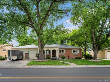 Charming single-story brick home with a well-manicured lawn and mature trees at 9656 Rensselaer Dr, Arvada, CO 80004