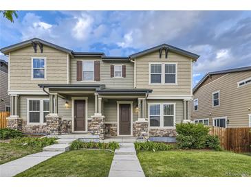 Charming townhome with stone accents, covered porch, and well-manicured front lawn at 2356 W 165Th Pl, Broomfield, CO 80023
