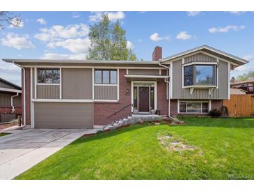Charming exterior featuring a well-maintained lawn, brick accents, and a cozy entrance at 12752 W Asbury Pl, Lakewood, CO 80228