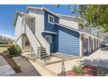 Charming multi-level home featuring blue and white siding, inviting front entrances with stairs, and low-maintenance landscaping at 1351 S Cathay Ct # 102, Aurora, CO 80017