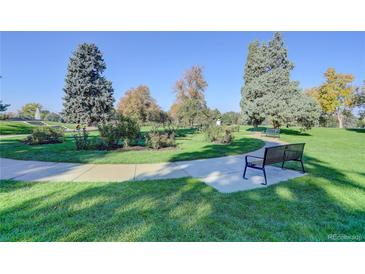 Beautiful community park with walking path and benches surrounded by lush greenery and mature trees at 1050 N Lafayette St # 408, Denver, CO 80218