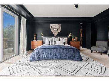 Modern bedroom featuring a dark accent wall, stylish rug, and walk-in closet at 25312 E Glasgow Pl, Aurora, CO 80016