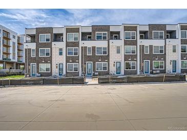 Modern townhome complex with brick facade, white accents, and individual entryways at 370 Geneva St, Aurora, CO 80010