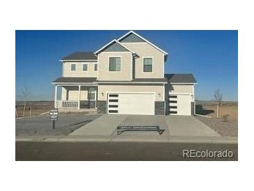 Charming two-story home featuring a covered porch, two-car garage, and modern design elements at 42964 Colonial Trl, Elizabeth, CO 80107